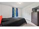 Cozy bedroom with black bedding, window with blue curtains, and wood dresser is great for relaxation at 558 Christys Way, Roxboro, NC 27574