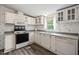 Bright kitchen featuring white cabinets, appliances, and plenty of natural light at 558 Christys Way, Roxboro, NC 27574