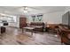 Open-concept living room with wood-look flooring, ceiling fan, and comfortable furniture at 558 Christys Way, Roxboro, NC 27574