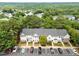 Aerial view of townhomes in a tree-filled neighborhood featuring parking spaces and manicured green spaces at 5717 Corbon Crest Ln, Raleigh, NC 27612