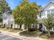 Beautiful townhomes with mature landscaping, sidewalks, and inviting entrances, creating a warm and welcoming atmosphere at 5717 Corbon Crest Ln, Raleigh, NC 27612