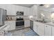 Well-lit kitchen featuring stainless steel appliances and white cabinets at 5717 Corbon Crest Ln, Raleigh, NC 27612