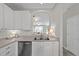 Stylish kitchen with white cabinets, stainless steel dishwasher, and pass-through to living area at 5717 Corbon Crest Ln, Raleigh, NC 27612