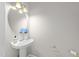 Stylish powder room with pedestal sink, decorative mirror, and modern lighting at 5717 Corbon Crest Ln, Raleigh, NC 27612
