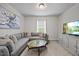 Cozy living room featuring a gray sofa, large tv and neutral colors at 601 Richlands Cliff Dr, Youngsville, NC 27596