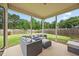 Covered patio with modern gray wicker seating and view of the lush, fenced backyard at 601 Richlands Cliff Dr, Youngsville, NC 27596