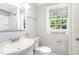 Clean bathroom featuring a white toilet, sink, shower, and window with natural light at 603 S Third St, Mebane, NC 27302