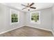 A cozy bedroom features wood-look flooring, two windows, and a ceiling fan at 603 S Third St, Mebane, NC 27302