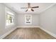 A cozy bedroom features wood-look flooring, two windows, and a ceiling fan at 603 S Third St, Mebane, NC 27302