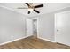 Bedroom with wood-look floors, neutral walls and ceiling fan with access to bathroom at 603 S Third St, Mebane, NC 27302