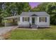 Charming one-story home featuring blue shutters, a covered porch, and a convenient carport at 603 S Third St, Mebane, NC 27302