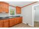 Kitchen with wooden cabinets, grey countertops, a sink, and a doorway to another room at 603 S Third St, Mebane, NC 27302
