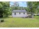 Rear exterior view showing the well-maintained lawn and a convenient covered parking area at 603 S Third St, Mebane, NC 27302