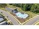 Aerial view of a community pool area with ample seating, a nearby parking lot, and a wooded area at 627 Georgias Landing Pkwy, Raleigh, NC 27603