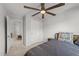 Neutral bedroom featuring a ceiling fan, patterned throw pillows, carpet, and an adjacent hallway and closet at 627 Georgias Landing Pkwy, Raleigh, NC 27603