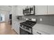 Modern kitchen features stainless steel appliances, gray subway tile backsplash, and white cabinets at 627 Georgias Landing Pkwy, Raleigh, NC 27603