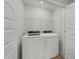 Well-lit laundry room with white washer, dryer, wire shelving, and white doors at 627 Georgias Landing Pkwy, Raleigh, NC 27603
