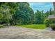 Long concrete driveway flanked by mature trees and greenery with a partial view of the home at 6305 Holly Ridge Rd, Rougemont, NC 27572
