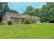 Beautiful brick home with a three-car garage, lush green lawn, and mature landscaping at 6305 Holly Ridge Rd, Rougemont, NC 27572