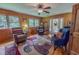 Cozy living room featuring wood walls, plush seating, and a ceiling fan for comfortable living at 6305 Holly Ridge Rd, Rougemont, NC 27572