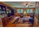 Spacious living room with wood paneling, a ceiling fan and built-in shelving at 6305 Holly Ridge Rd, Rougemont, NC 27572