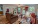 Bright living room with a fireplace, large windows, and warm, inviting furniture at 6305 Holly Ridge Rd, Rougemont, NC 27572