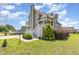 Backyard with well manicured lawn and mature landscaping leading to a home with a screened porch at 656 Atkins Rd, Fuquay Varina, NC 27526