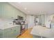 Bright eat-in kitchen featuring stainless appliances, sage colored cabinets, white subway tile backsplash, and wood floors at 656 Atkins Rd, Fuquay Varina, NC 27526