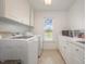 Bright laundry room with modern washer and dryer, white cabinetry, and built in sink and storage at 656 Atkins Rd, Fuquay Varina, NC 27526