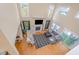 Open living room featuring hardwood floors, a cozy fireplace, and lots of natural light from large windows at 656 Atkins Rd, Fuquay Varina, NC 27526