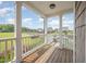Relax on this covered porch with wooden flooring, offering views of the landscaped yard and neighborhood at 656 Atkins Rd, Fuquay Varina, NC 27526