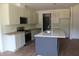 Well-lit kitchen with stainless steel appliances, an island with a sink, and ample storage cabinets at 70 Basil Ct, Franklinton, NC 27525