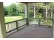 View of a porch with a railing looking out onto a grass field and lush green trees at 70 Basil Ct, Franklinton, NC 27525