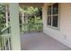 View of the porch with green rails and a window looking out on a wooded area at 70 Basil Ct, Franklinton, NC 27525