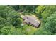 An aerial shot of a brick home surrounded by mature trees and a well-manicured yard at 712 Orange High School Rd, Hillsborough, NC 27278