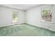Bright bedroom featuring green carpet, white walls, and natural light from two windows at 712 Orange High School Rd, Hillsborough, NC 27278