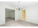 Formal dining room featuring a traditional chandelier, neutral paint and carpet and open access to the adjacent rooms at 712 Orange High School Rd, Hillsborough, NC 27278