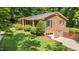 Brick home featuring an attached garage, a well-manicured lawn and lush landscaping at 712 Orange High School Rd, Hillsborough, NC 27278