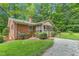 Brick home exterior showcasing a screened-in porch and mature landscaping at 712 Orange High School Rd, Hillsborough, NC 27278