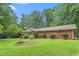 Lush lawn and brick house exterior with screened-in porch and established shrubbery at 712 Orange High School Rd, Hillsborough, NC 27278