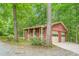 Two-car detached garage/outbuilding with neutral paint surrounded by mature trees at 712 Orange High School Rd, Hillsborough, NC 27278