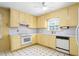 Traditional kitchen features yellow cabinets, white countertops, and black-and-white tile flooring at 712 Orange High School Rd, Hillsborough, NC 27278