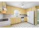 Traditional kitchen featuring classic appliances, yellow cabinetry and neutral counter tops at 712 Orange High School Rd, Hillsborough, NC 27278