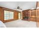 Cozy living room featuring wood paneling, brick fireplace, and a ceiling fan at 712 Orange High School Rd, Hillsborough, NC 27278