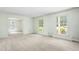 Bright living room featuring neutral carpet, fresh paint, an abundance of windows and open access to the dining room at 712 Orange High School Rd, Hillsborough, NC 27278