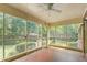 Screened-in sunroom features ceiling fan and views of the lush, wooded backyard at 712 Orange High School Rd, Hillsborough, NC 27278