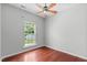 Bright bedroom with hardwood floors, a ceiling fan, and a large window overlooking the backyard at 760 Stackhurst Way, Wake Forest, NC 27587