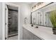 Bathroom featuring a long vanity and a shower with black tile at 7708 Falcon Rest Cir, Raleigh, NC 27615
