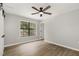 A bedroom with a wood ceiling fan, nice floors, and a window with a backyard view at 7708 Falcon Rest Cir, Raleigh, NC 27615