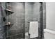 Shower with black tile, a glass enclosure, and a metal shelf at 7708 Falcon Rest Cir, Raleigh, NC 27615